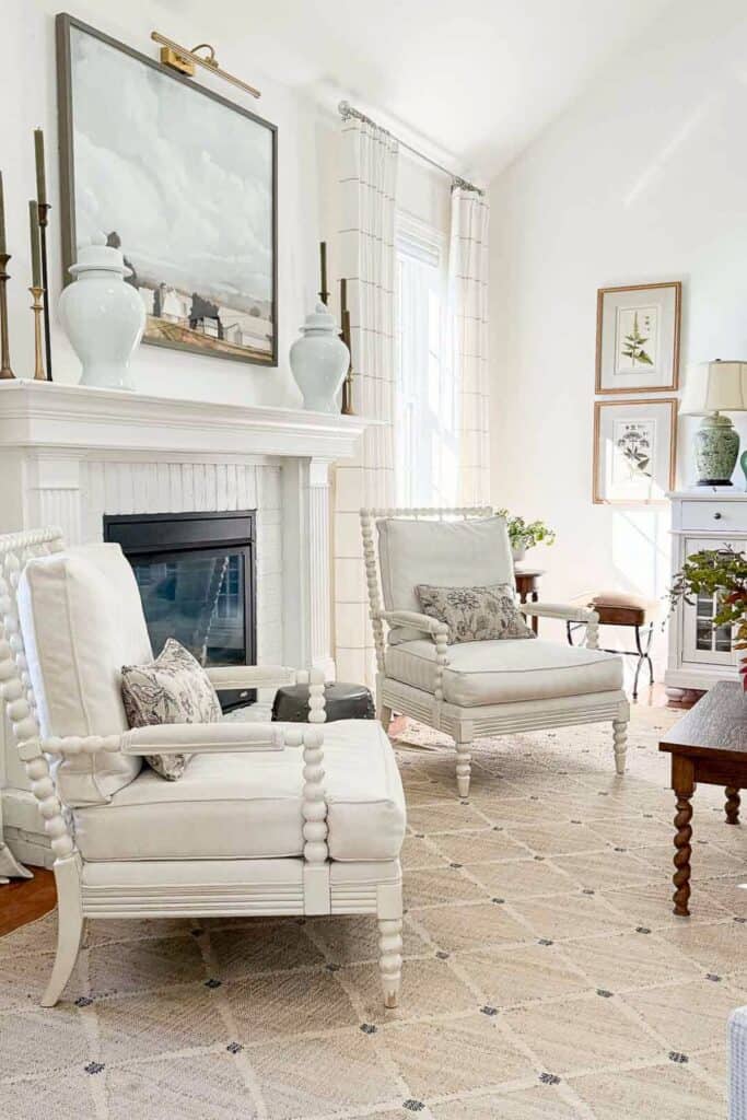 two white chairs flanking a fireplace