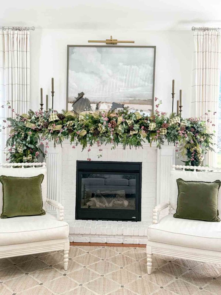 Full image of the fireplace with an evergreen garland on the mantel.