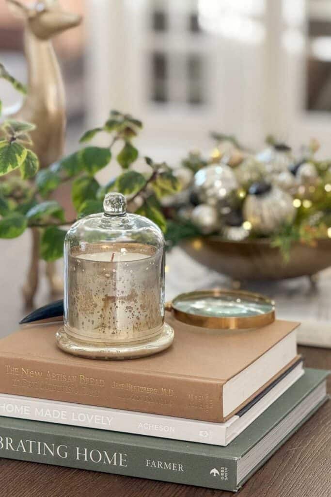 a candle on a coffee table decorated for Christmas