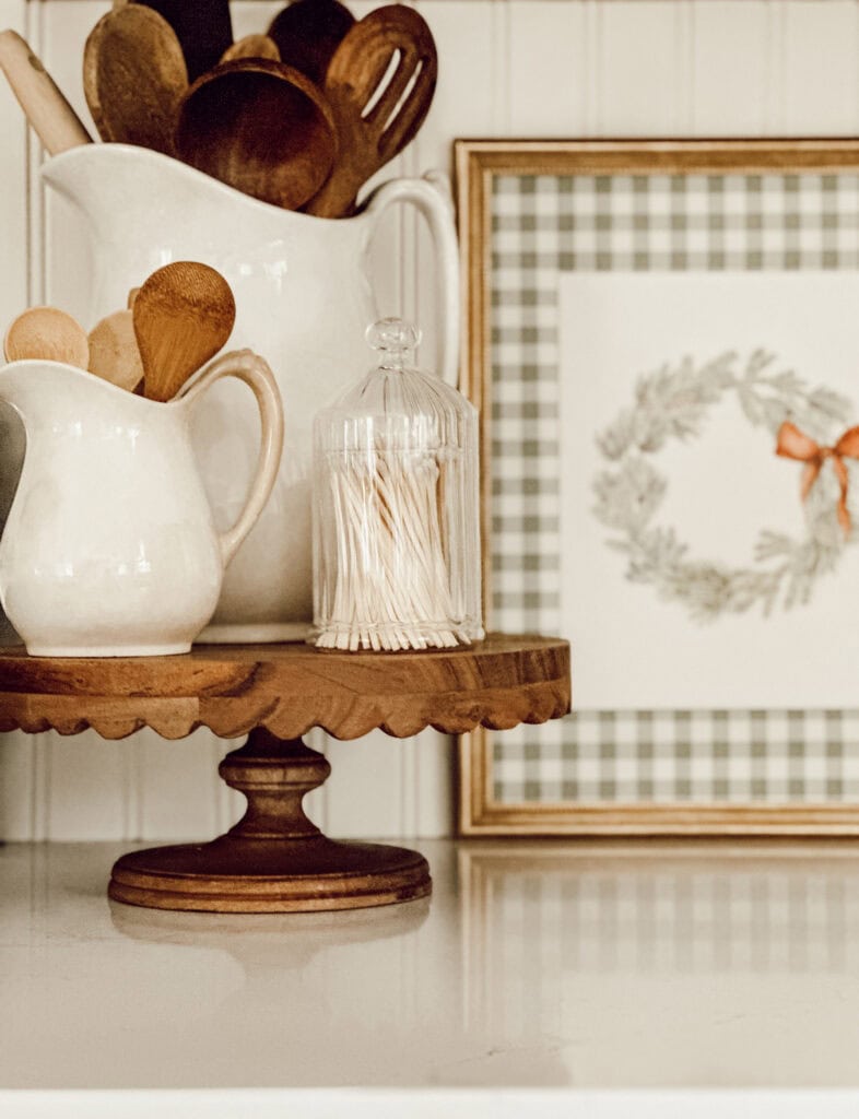 wooden pedestal with a pitchers, filled with wooden spoons