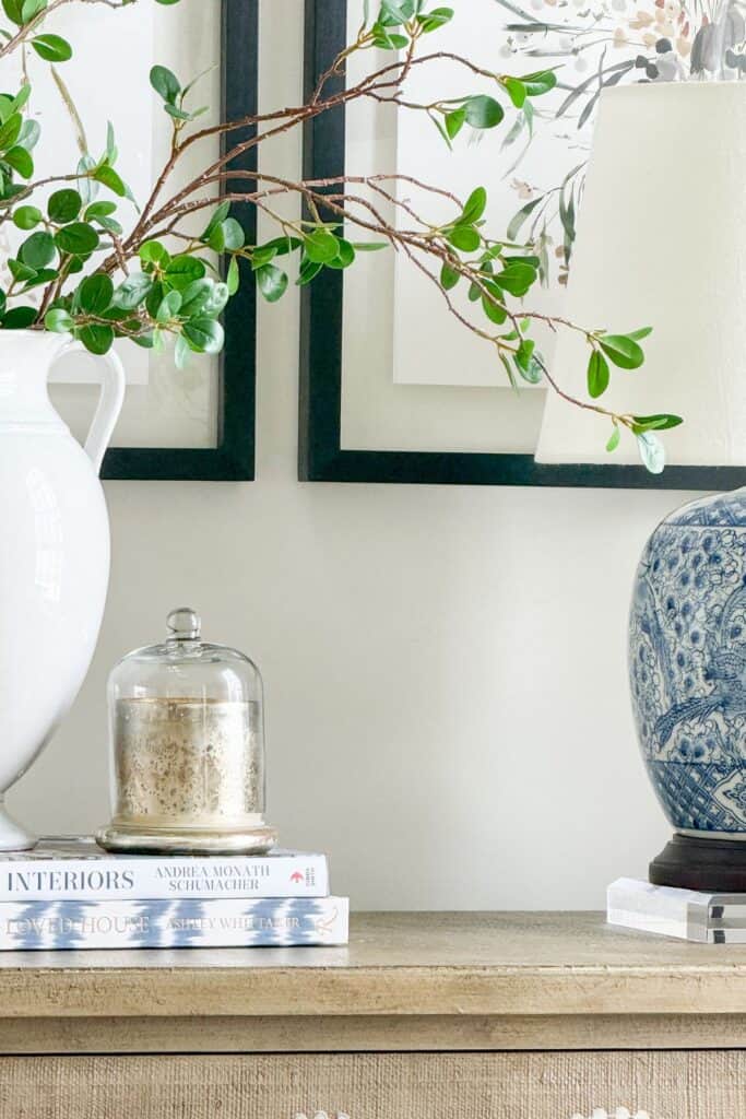 Ten minute decorating idea showing a styled console table with stacked books, a lamp, and greenery for a finished look