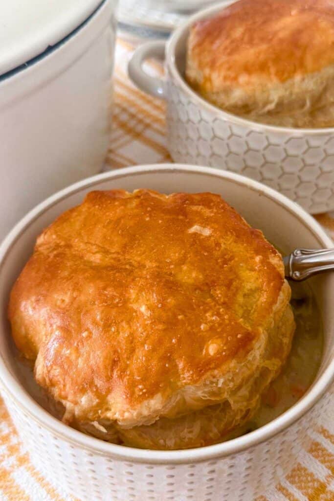 Sausage white bean and Swiss chard soup topped with a golden baked puff pastry lid