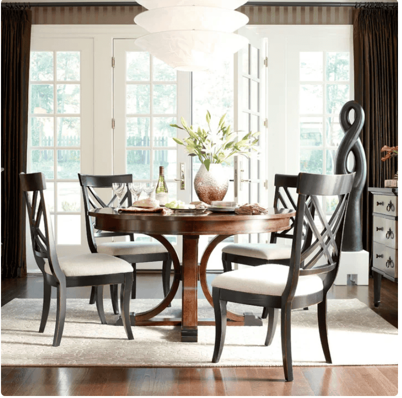 antique styled round dining table with tall back modern chairs