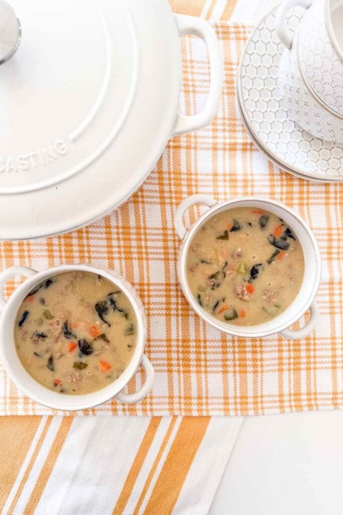 Sausage white bean and Swiss chard soup in individual bowls before adding puff pastry lids