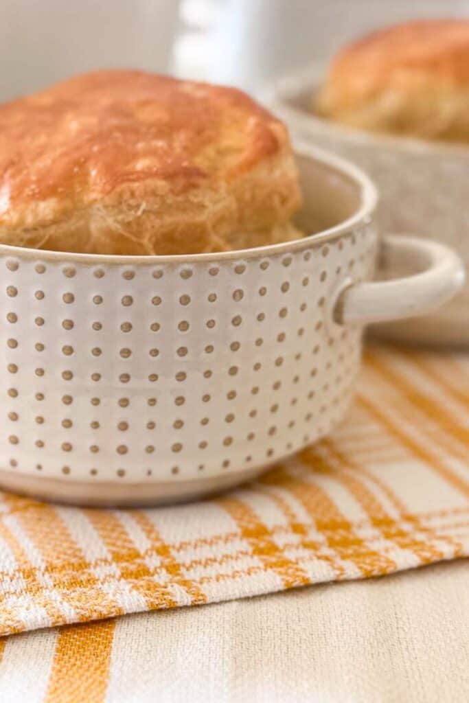 Sausage white bean soup served in a bowl topped with a golden puff pastry lid
