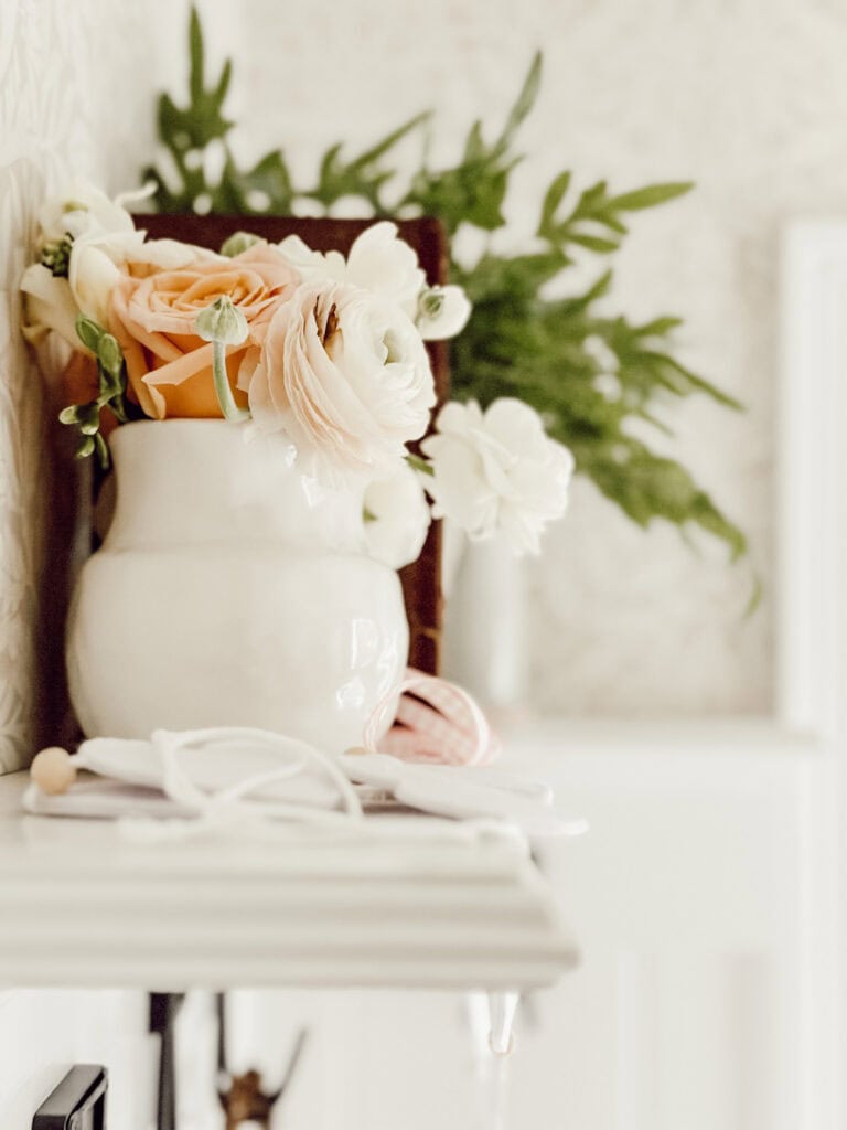 shelf with a white crock of flowers