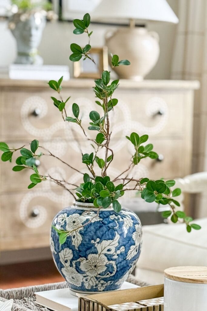 blue and white floral vase with simple greenery styled on coffee table for a collected look without clutter