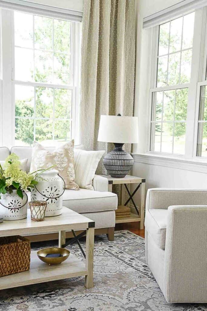 Living room coffee table styled with multiple decorative items, books, and plants creating a busy surface.