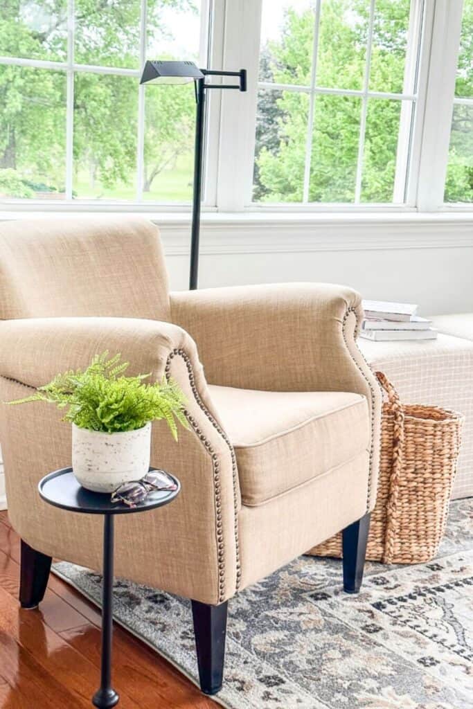 Bright winter living room with an upholstered chair, natural light, and a small green plant on a side table for a fresh February look