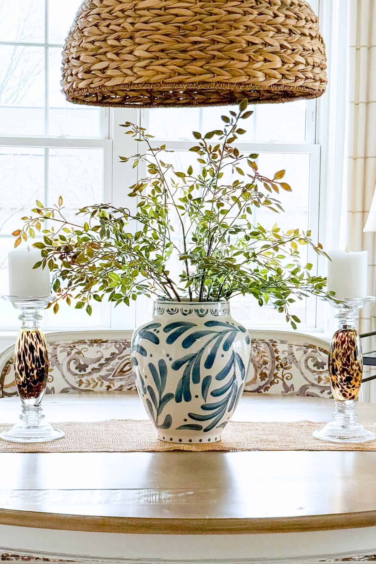 blue and white vase on a dining room filled with spring greens.
