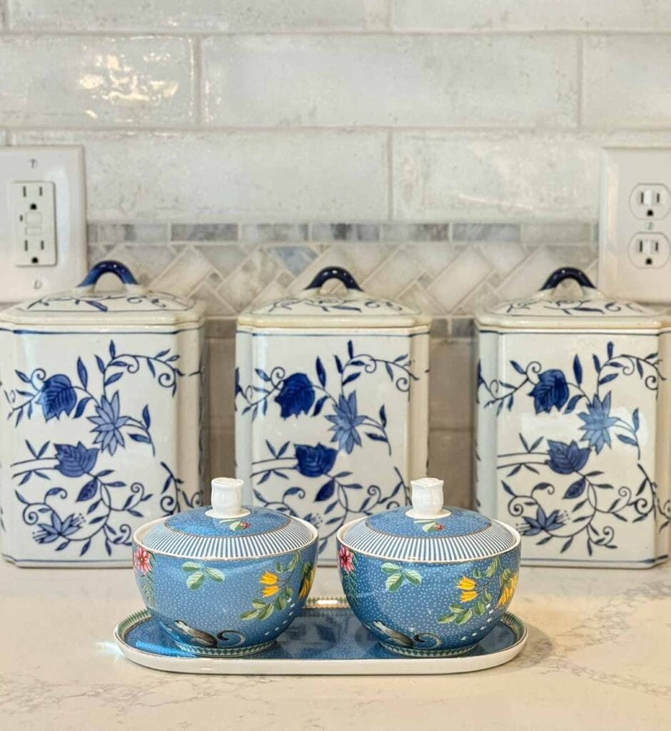 blue and white canisters with small blue containers on a kitchen counter