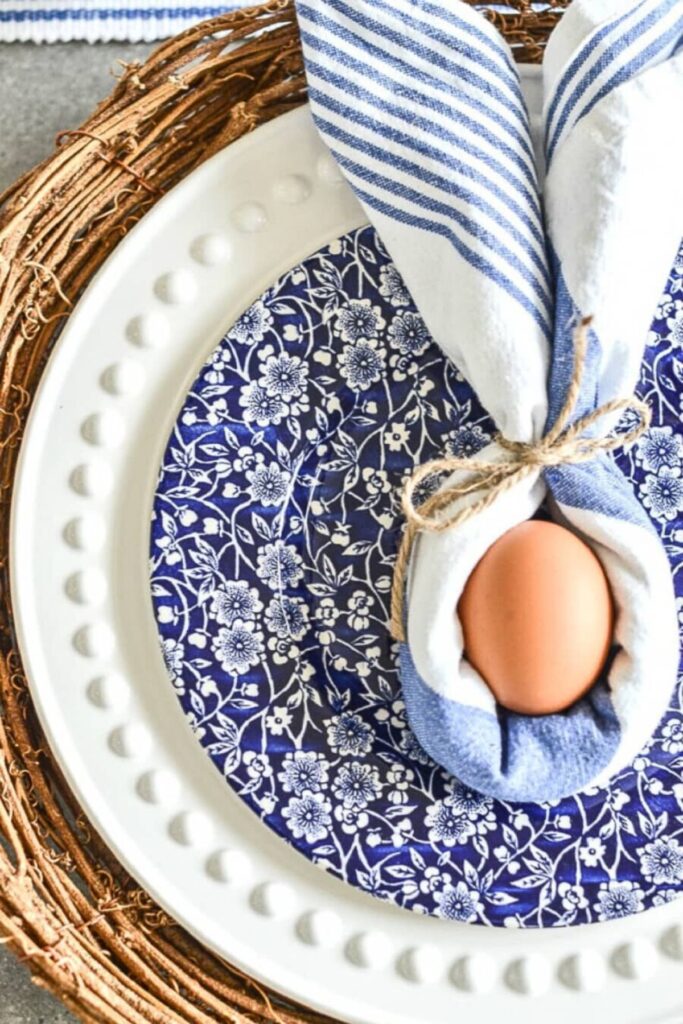 bunny napkin fold with egg on blue and white spring table setting