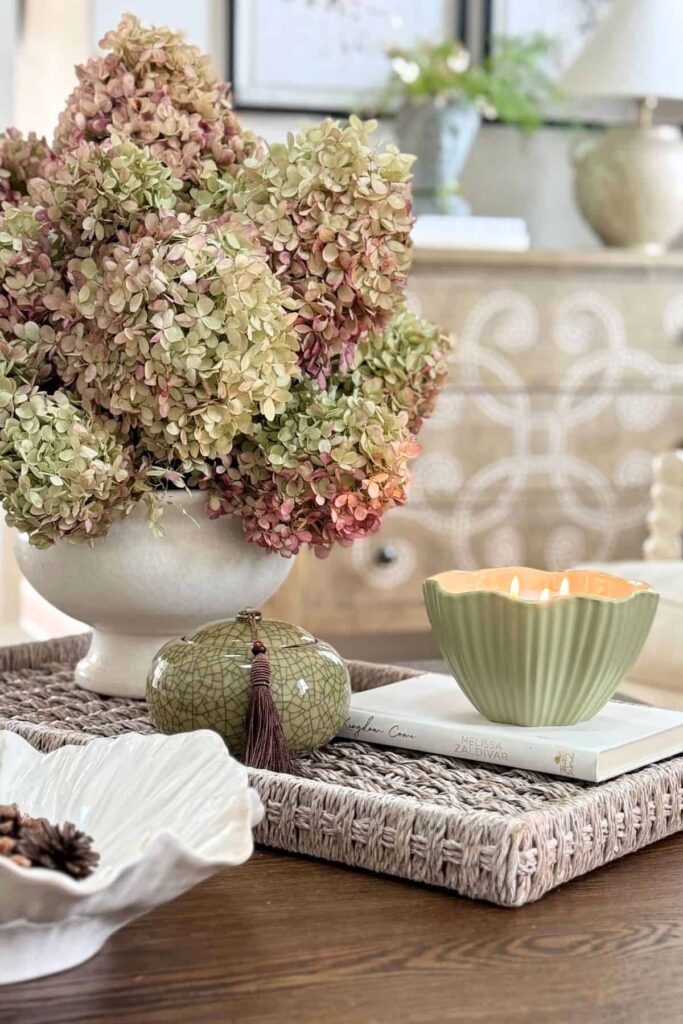 coffee table styled with tray, hydrangeas in vase, candle and decorative accents
