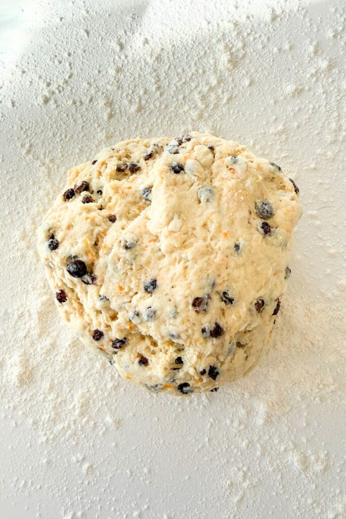 Irish soda bread scone dough with currants on a floured surface ready to be shaped
