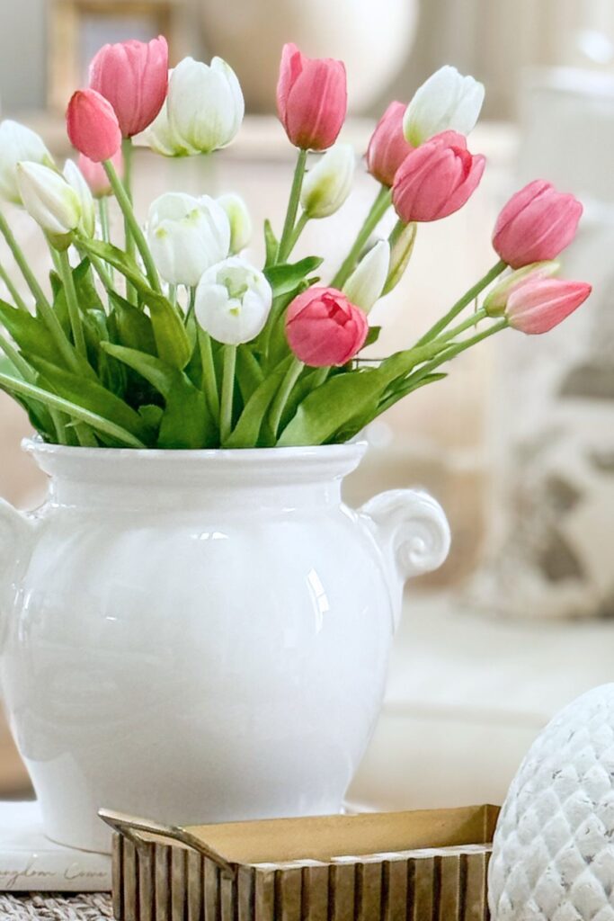 close up of spring tulips in a white urn vase.