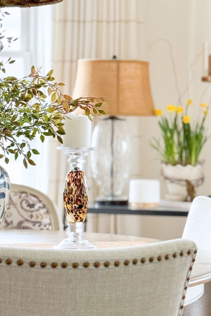 dining chair with bunny pillow beside a round dining table decorated for spring