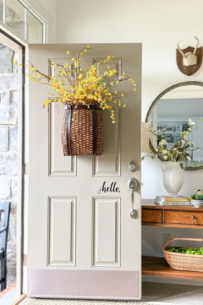 simple spring home decor with yellow flowering branches on front door and light filled entryway