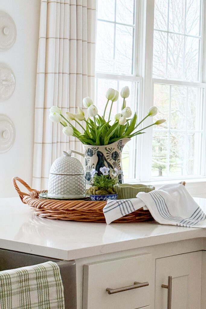 spring kitchen island styled with white tulips in a pitcher on a woven tray with simple seasonal decor