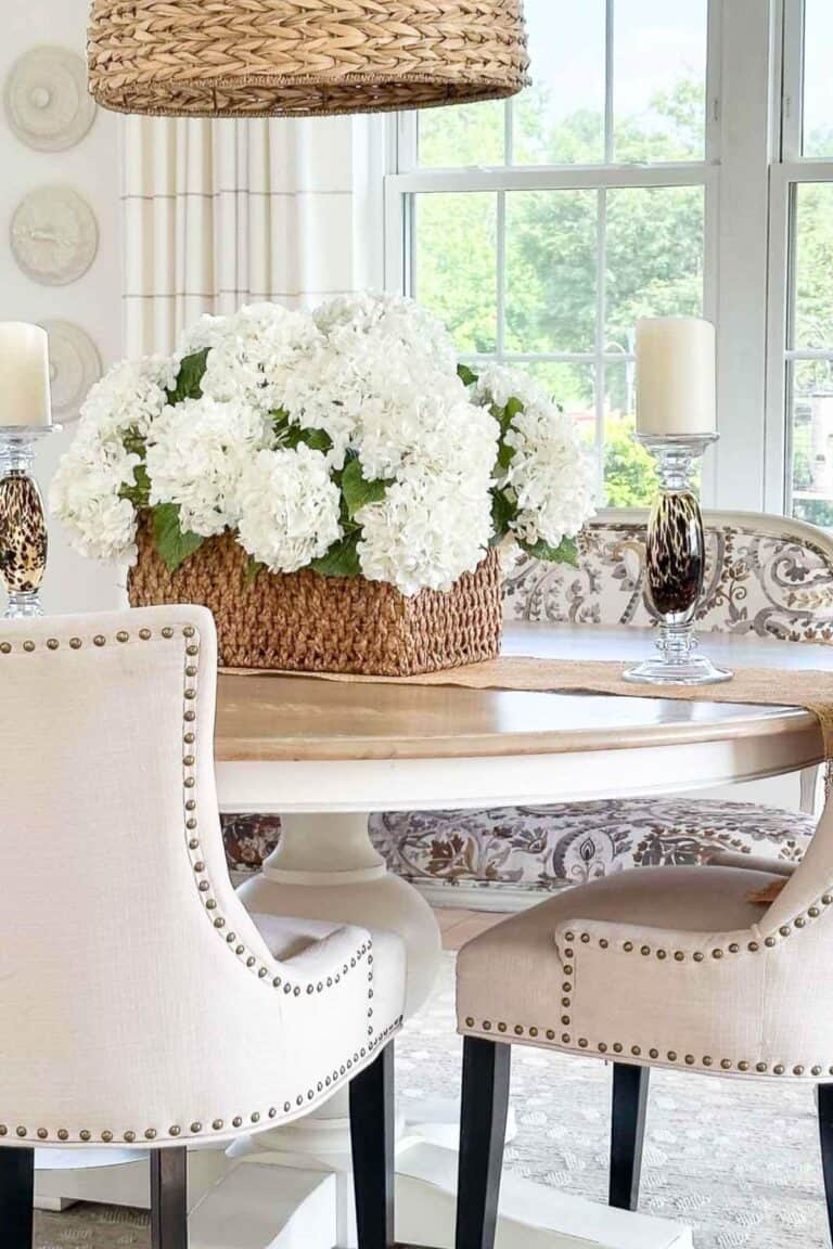 a basket of white hydrangeas on a dining room table
