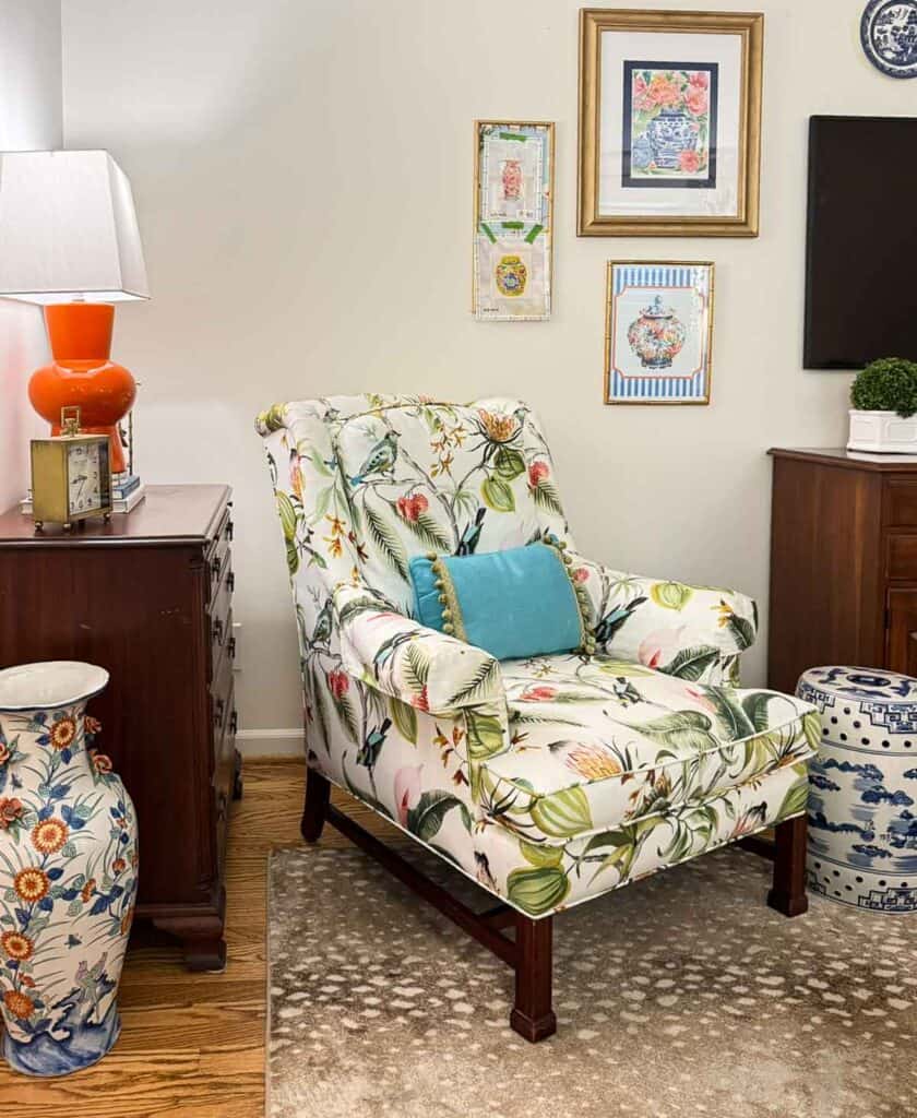 colorful chair in a living room with dark wood chest and console table