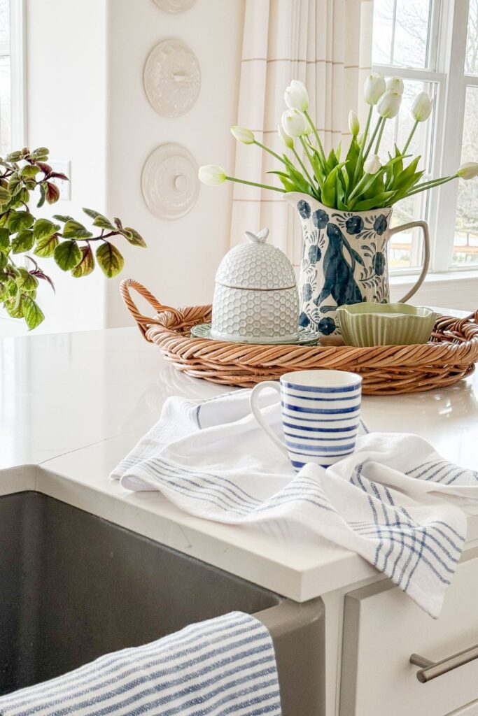 blue and white kitchen decor with striped mug, tulips, and tray on countertop