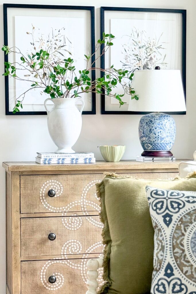 blue and white lamp styled on dresser with greenery and neutral decor