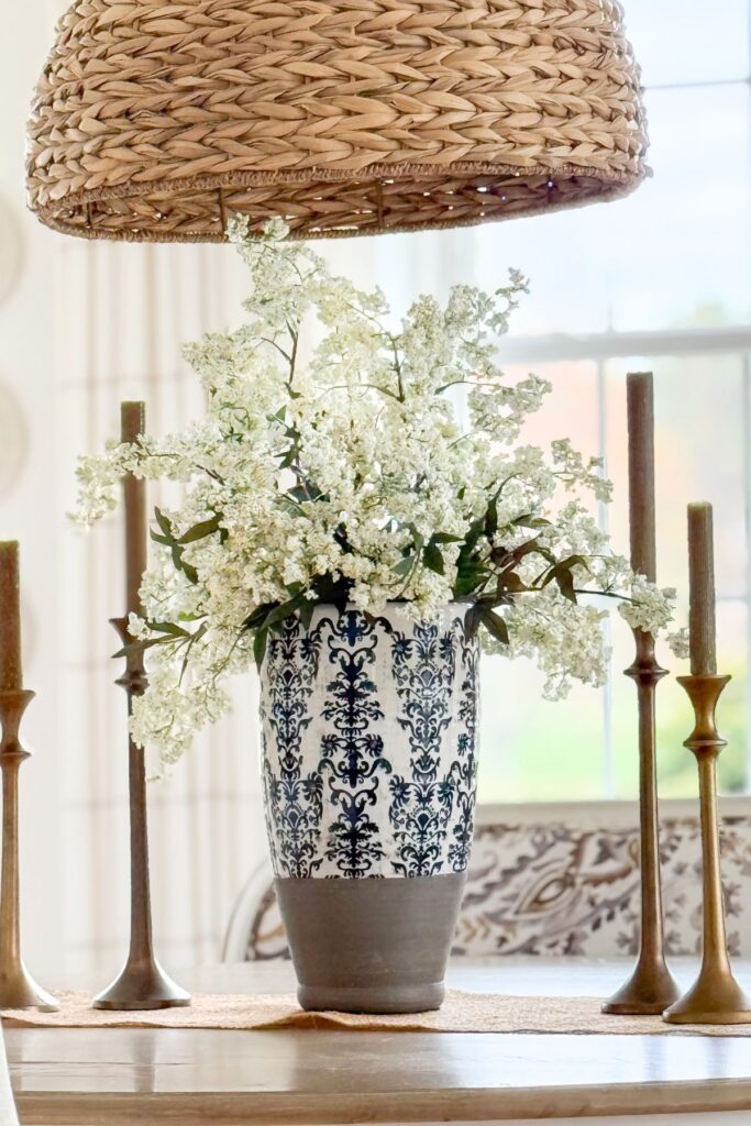 blue and white vase with white flowers styled with wood tones and neutral decor
