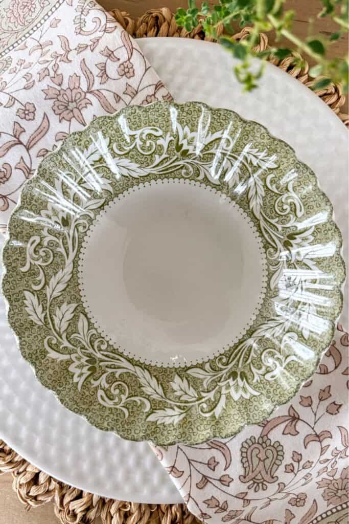 green, brown, and white place setting and napkin on a wicker placemat