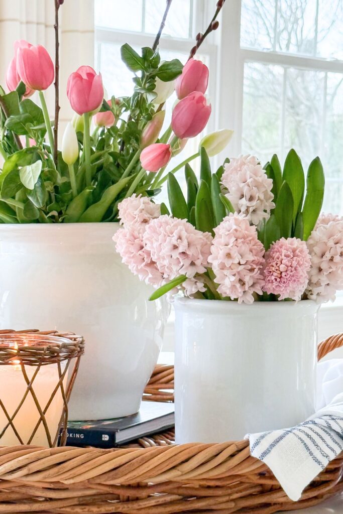 kitchen island styled with spring flowers tulips and hyacinths on a tray with a candle in a light kitchen