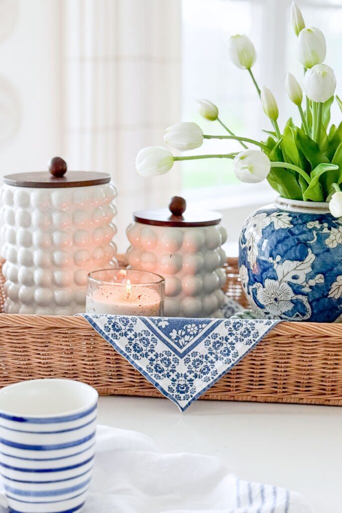kitchen island styled with tray tulips blue and white vase candle and tea towel in a bright kitchen