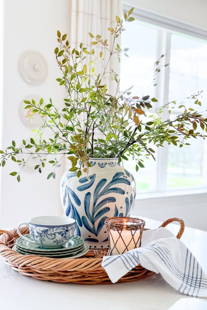 kitchen island styled with tray blue and white vase greenery candle teacup and tea towel in a bright kitchen