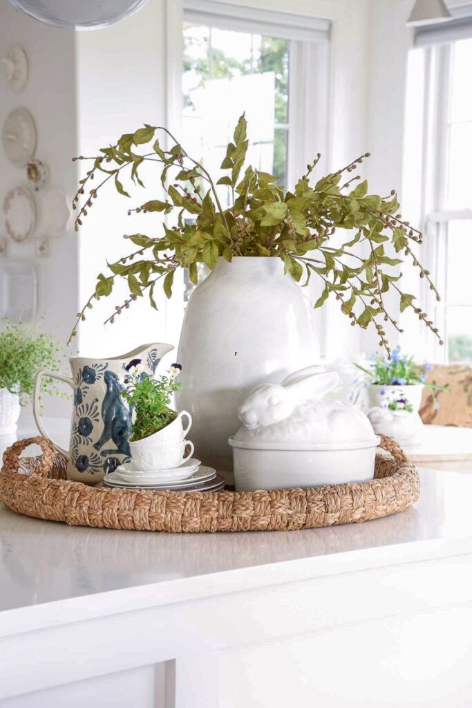 kitchen island styled with tray vase greenery teacups and seasonal decor in a light spring kitchen