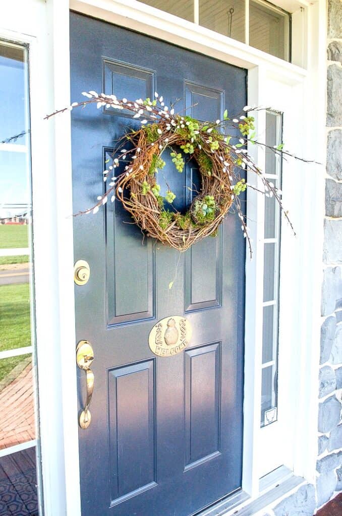 Front door with wreath and hospitality plate detail for a welcoming entry