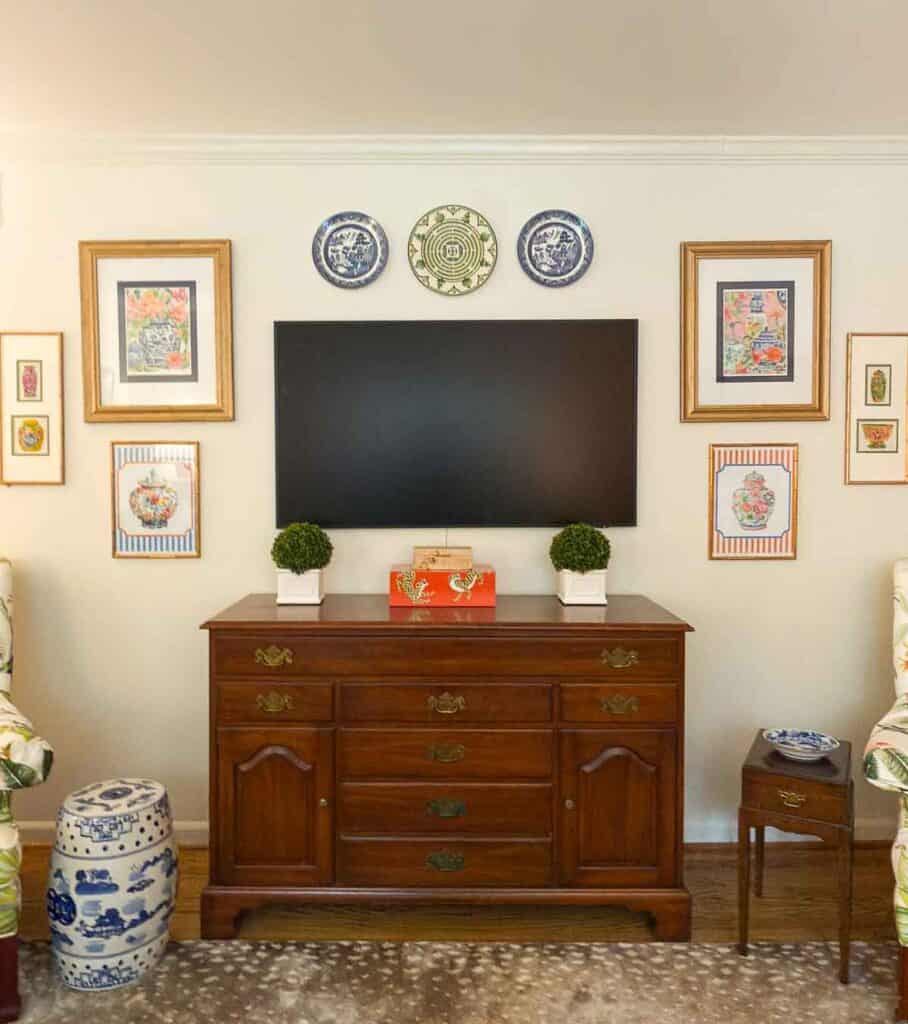 buffet in a beige room with a tv above it.