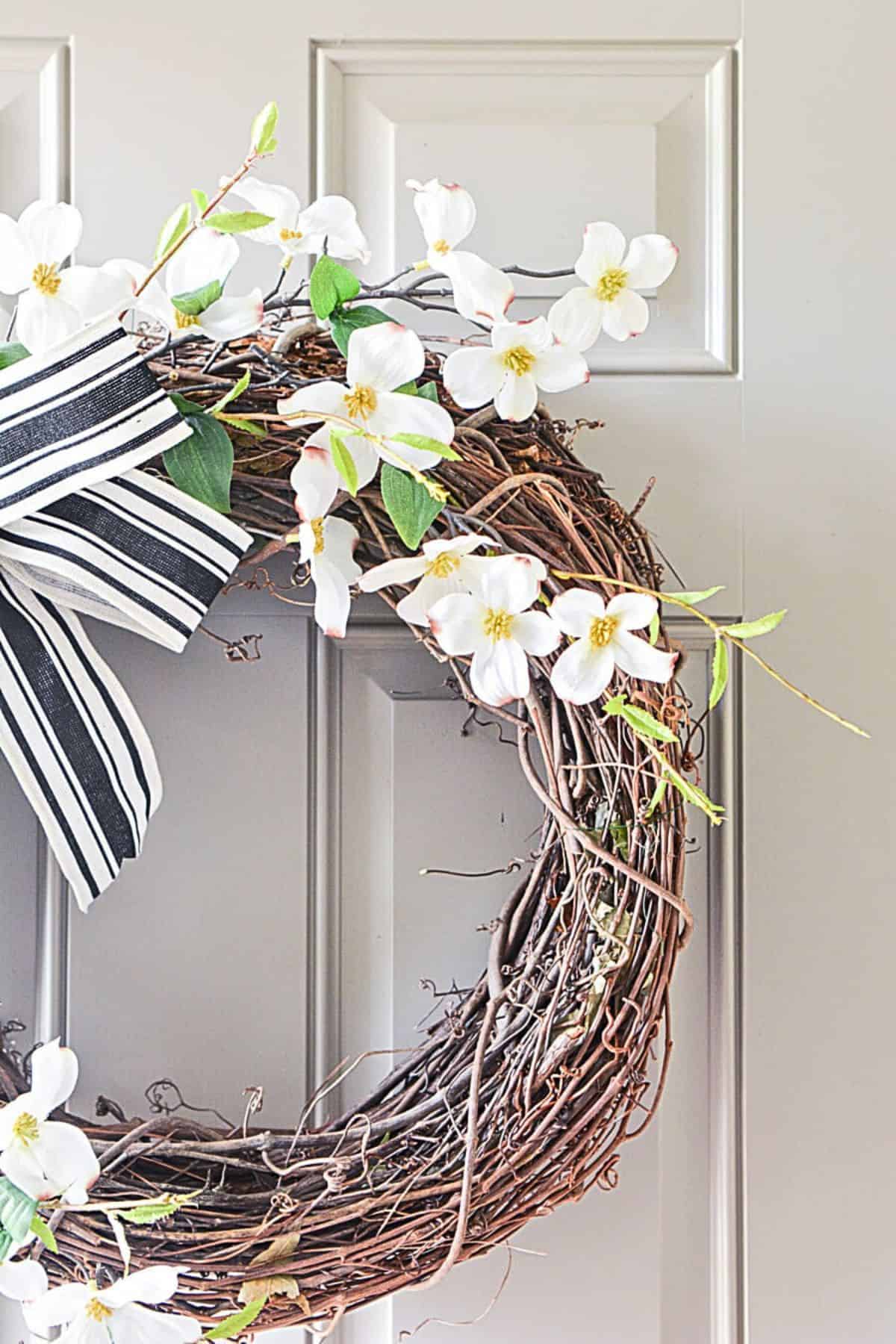 Dogwood wreath on grapevine base with ribbon for summer front door decor