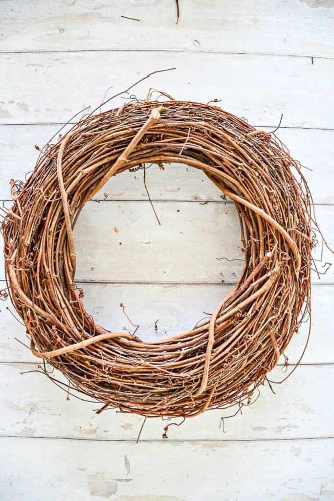 Grapevine wreath base used to create a full front door wreath for summer decorating