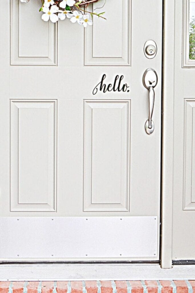 Front door with simple hello decal and clean hardware for a welcoming entry