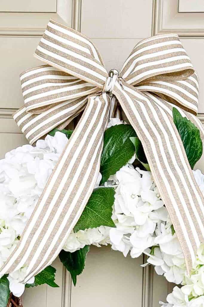Striped bow on white hydrangea wreath for summer front door decorating