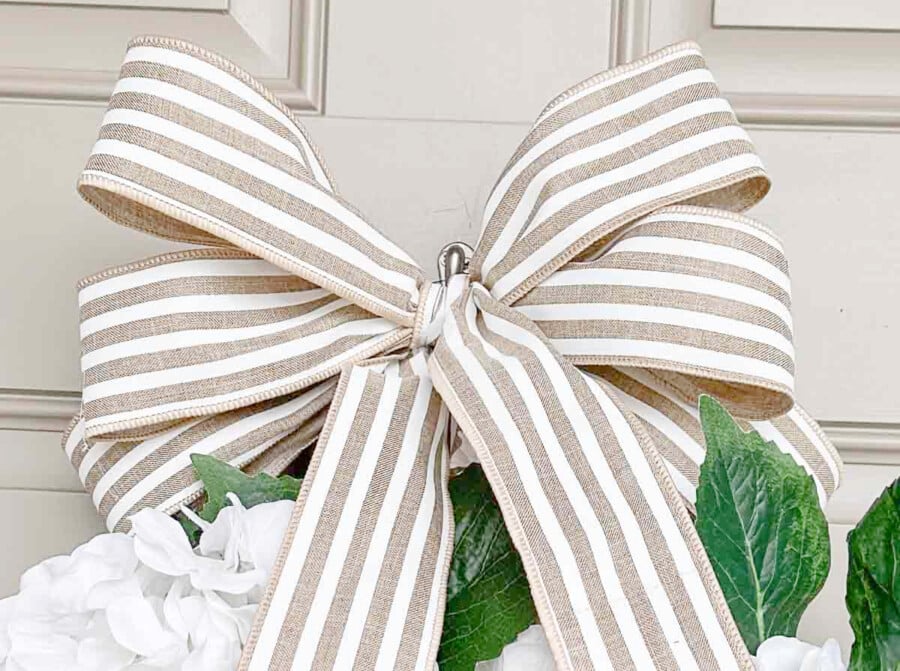 Close up of striped ribbon bow on hydrangea wreath for front door decorating
