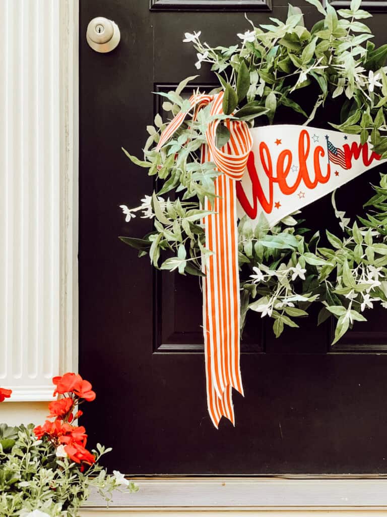 wreath on a door with a welcome banner