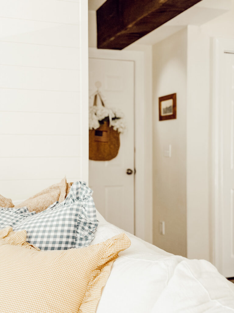 ruffled pillows peaking up in the image and a basket on the door in the background