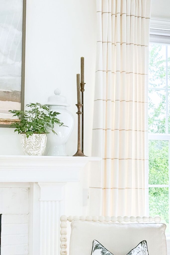 green plant in a pretty green and white pot on a mantel