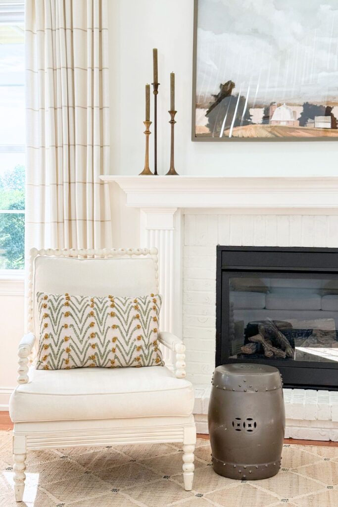 simple trio of candles flanking a painting on a mantel