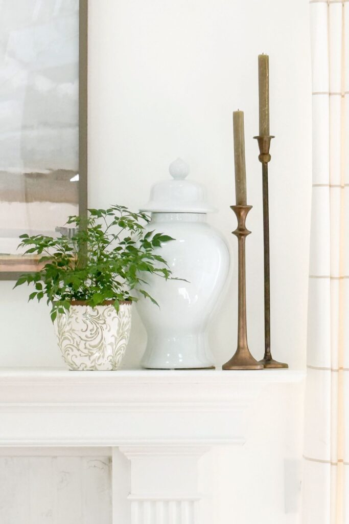 varied heights of decor on one side of a mantel