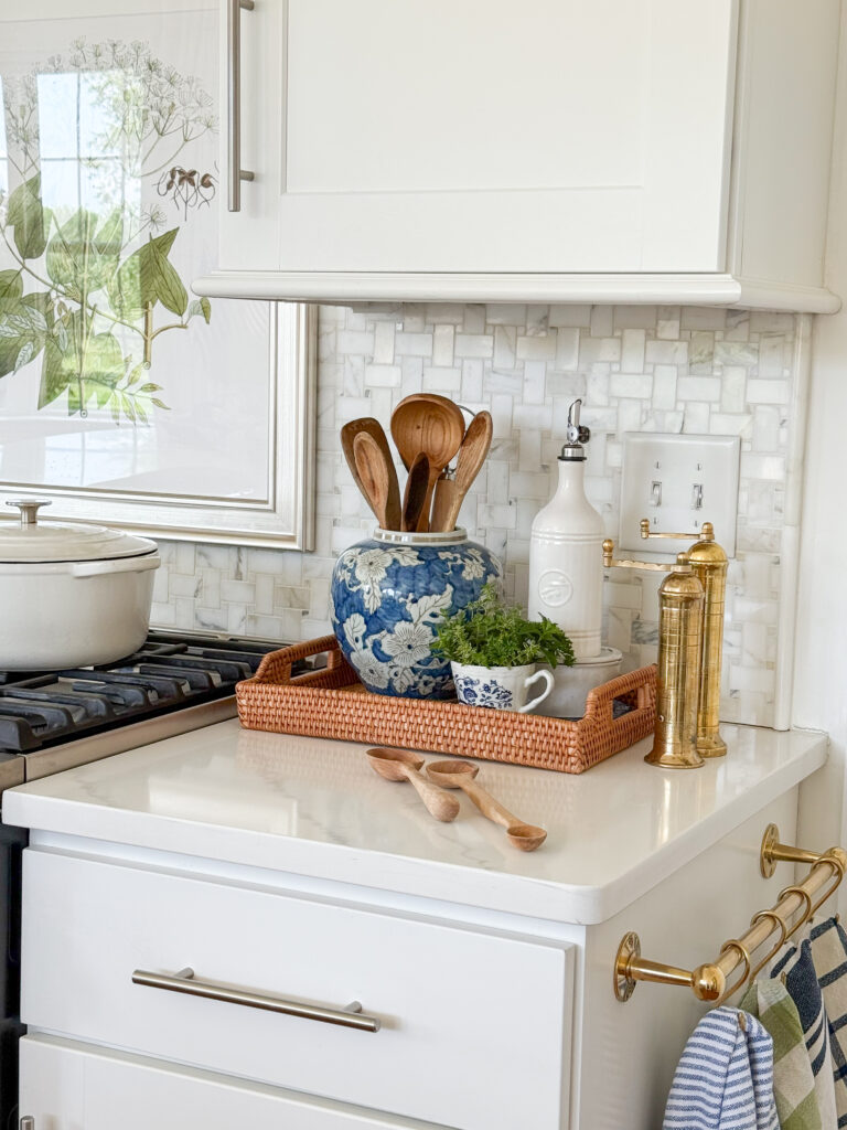 Blue and white ginger jar filled with wooden spoons styled on a kitchen tray with brass accents