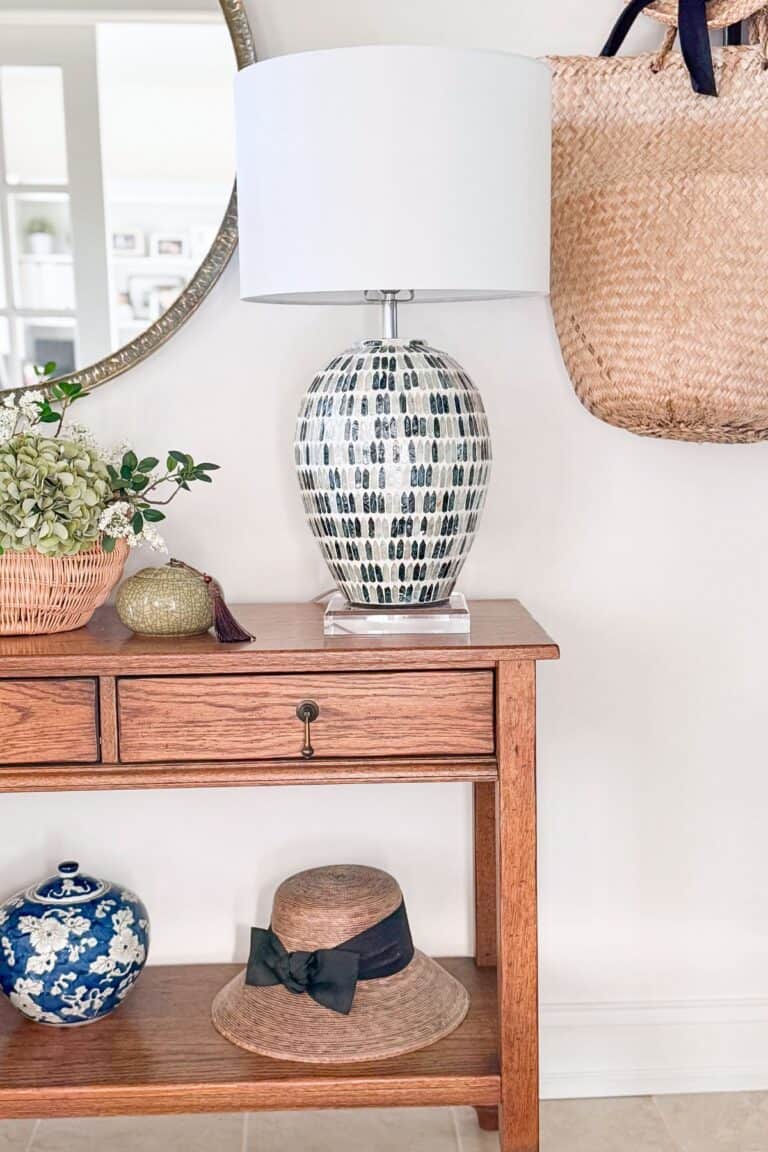 a blue mosaic lamp on a wooden console