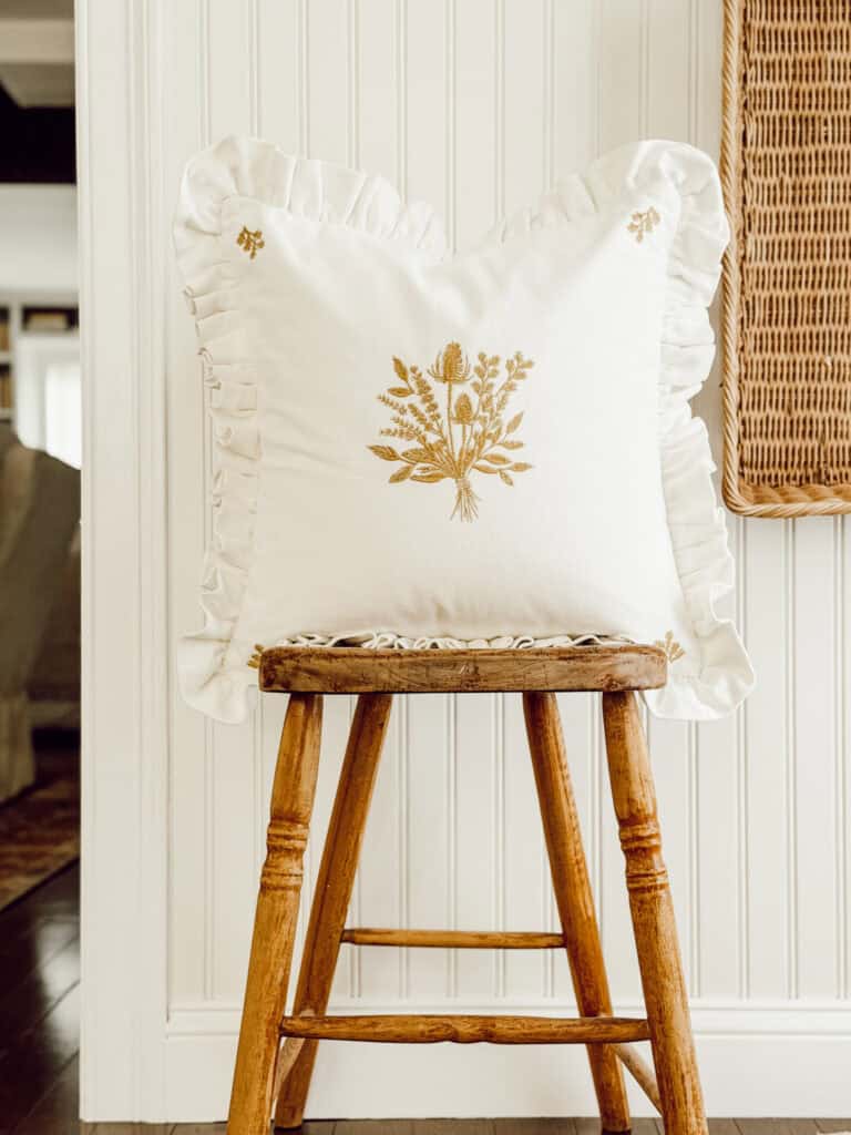 pretty white ruffled pillow with a fall motif on the front