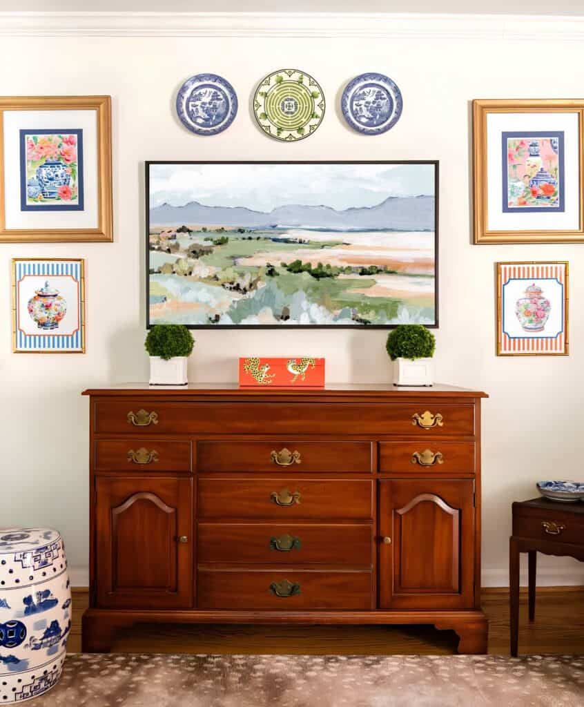 wooden chest with plates and pictures on the wall behind it