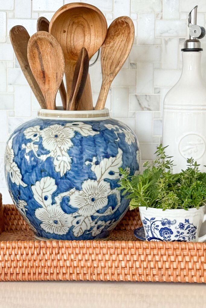 Blue and white ginger jar used as a kitchen utensil holder filled with wooden spoons