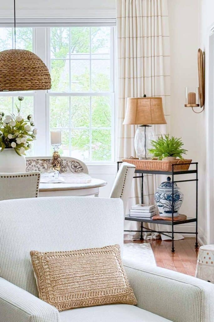 Blue and white ginger jar styled on a black accent table with a lamp and fern in a living room